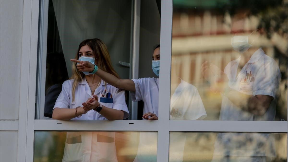 Personal sanitario del Hospital Fundación Jiménez Díaz de Madrid devuelve los aplausos durante el homenaje que le tributa la ciudadanía.