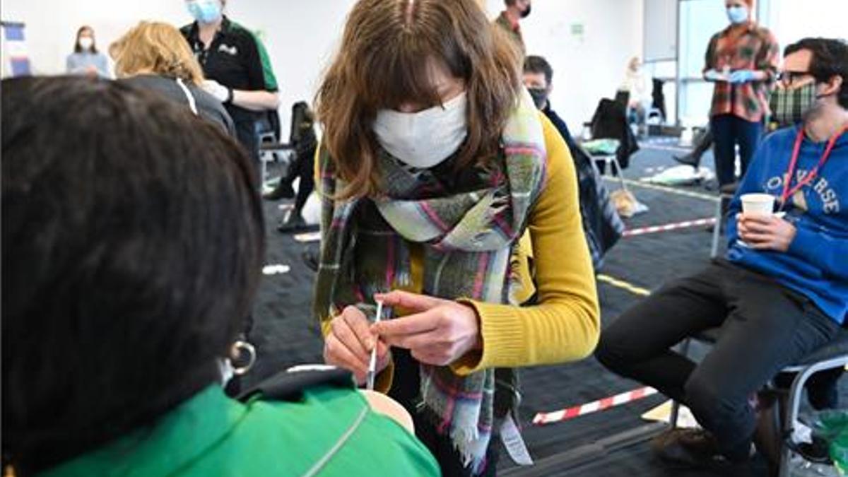 Una voluntaria aprende como administrar la vacuna en Canary Wharf.