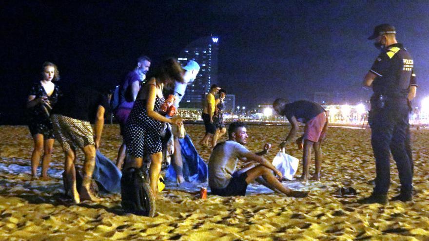 Un grup de persones que feia el &#039;botellón&#039; a la platja de la Barceloneta s&#039;aixeca davant la presència d&#039;agents de la Guàrdia Urbana |