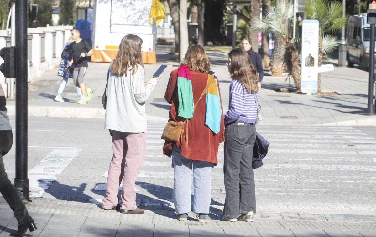 Unas chicas esperan en un paso de cebra en Palma.  | ENRIQUE CALVO