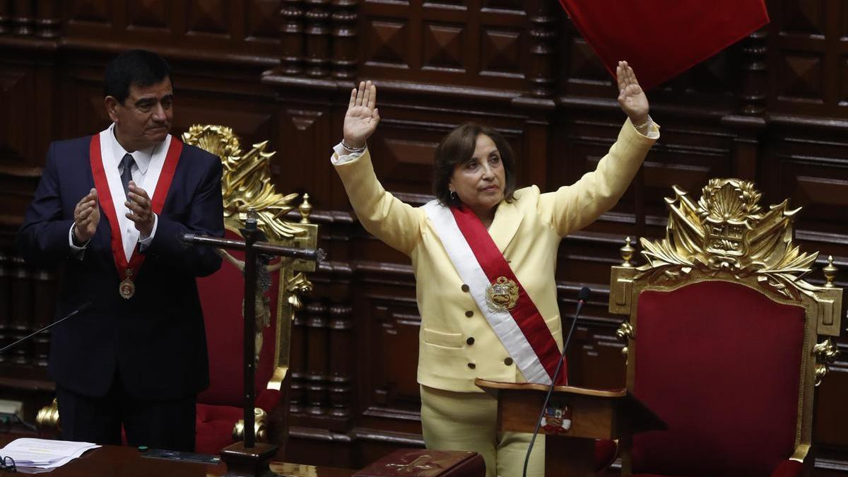 La abogada Dina Boluarte saluda tras ser juramentada como nueva presidenta del Perú por el presidente del Congreso, José Daniel Williams Zapata.