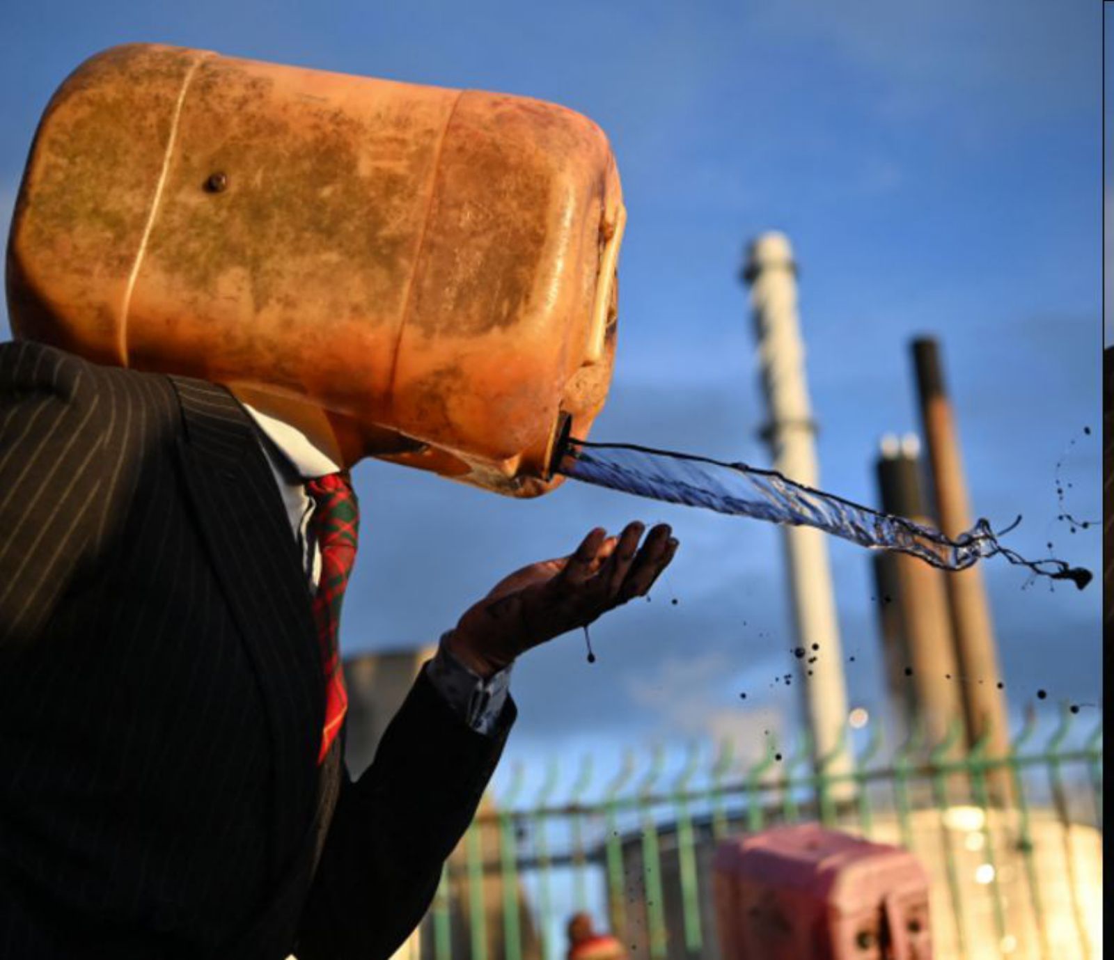 Un activista ambiental protesta ante una refinería.