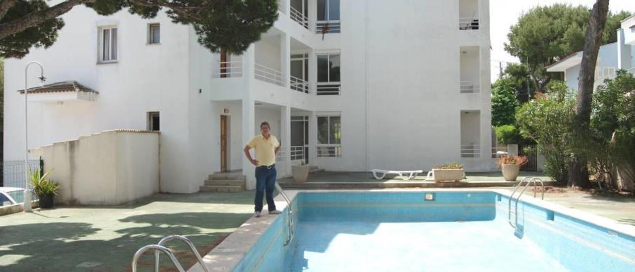Un afectado junto a la peligrosa piscina vacía del antiguo aparthotel reconvertido.