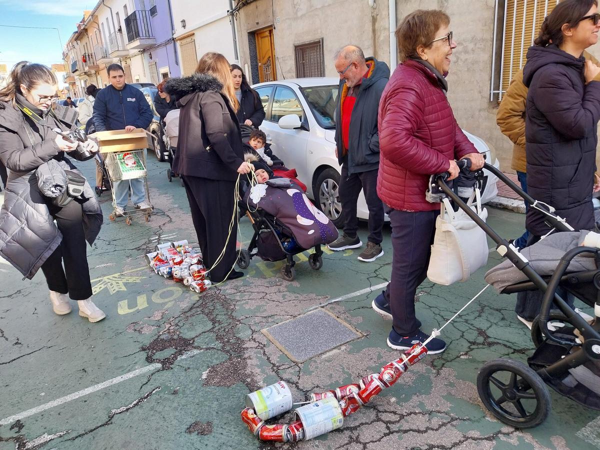 Las familias arrastran tiras de latas atadas para hacer ruido.