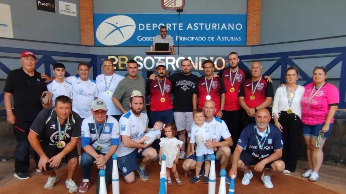 Integrantes de El Piles, de rojo, y El Arenal, de blanco, posando con organizadores y directivos tras la final absoluta disputada en Sotrondio.