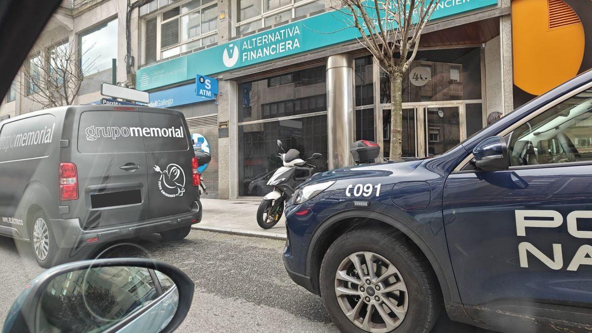 Coche de la Policía Nacional y de la funeraria frente al edificio donde se hallaba la mujer fallecida.