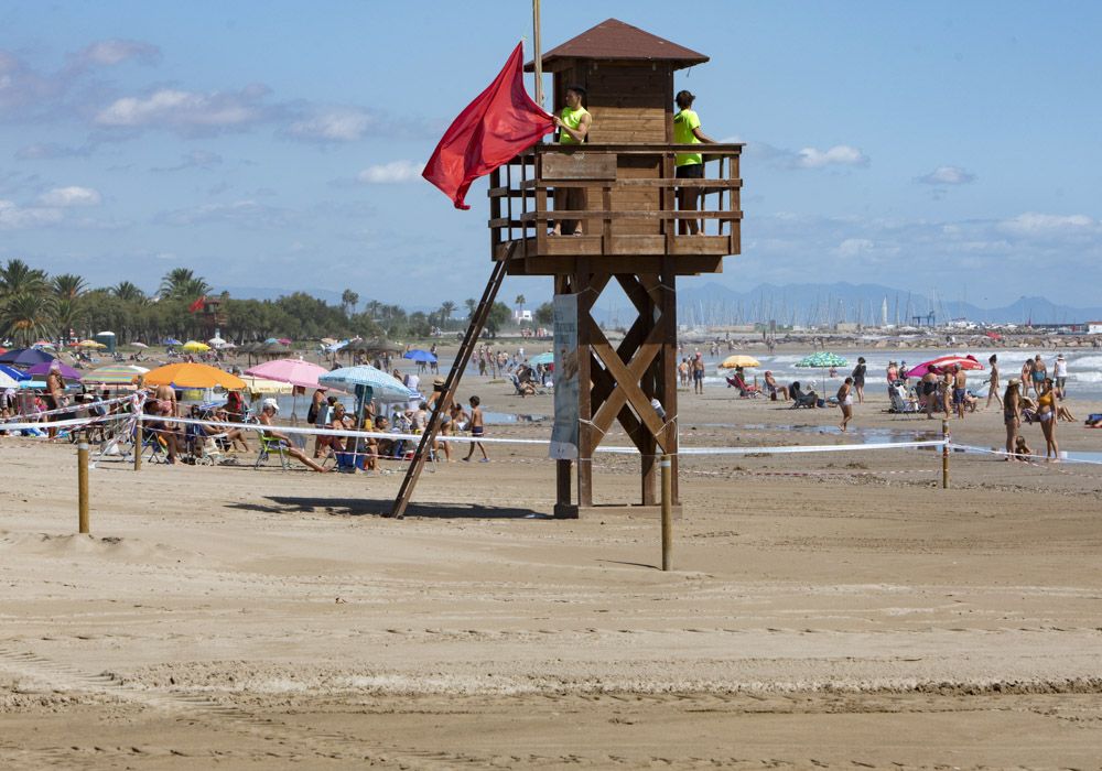 Contraste en la playa del Puerto de Sagunto, con una zona cerrada por los daños de las lluvias.