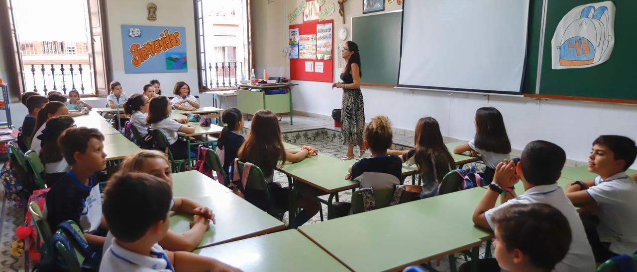 Una profesora impartiendo clase en el primer día de curso escolar.