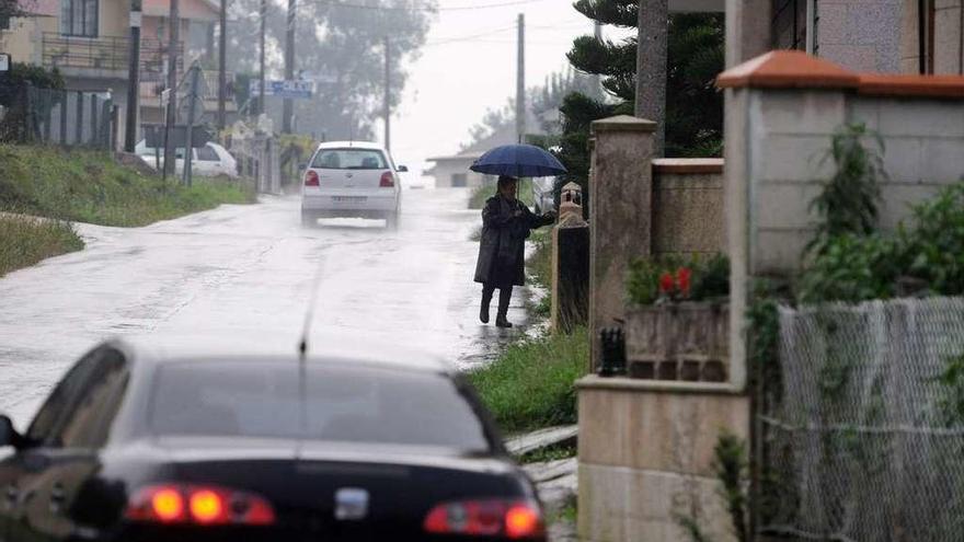 Una mujer camina por el margen de la carretera en Campelo. // Gustavo Santos