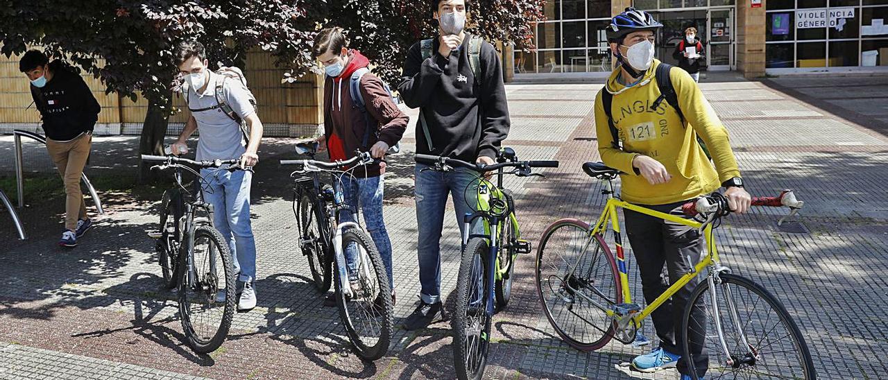 Por la izquierda, los alumnos Alejandro Torres, Adrián Lorca y Nicolás Sandoval, con su profesor Fran Flórez, ayer, al salir de clase en el IES El Piles, con sus bicicletas.