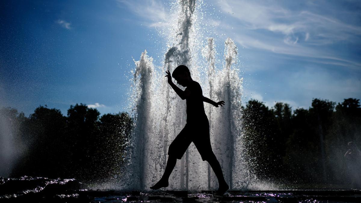 Un niño camina junto a una fuente en el parque Lustgarten en Berlín,  por la ola de calor