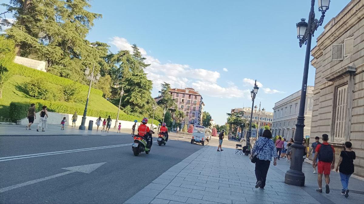 Agentes de movilidad persiguiendo a dos tuk tuk frente al Palacio Real