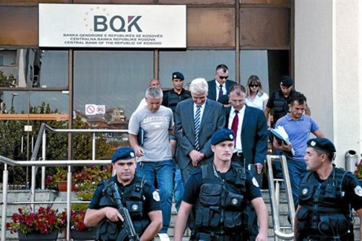 Policies kosovars s’emporten detingut Hashim Rexhepi (darrere, al centre), governador del Banc Central, divendres, a Pristina. Policies kosovars s’emporten detingut Hashim Rexhepi (darrere, al centre), governador del Banc Central, divendres, a Pristina.