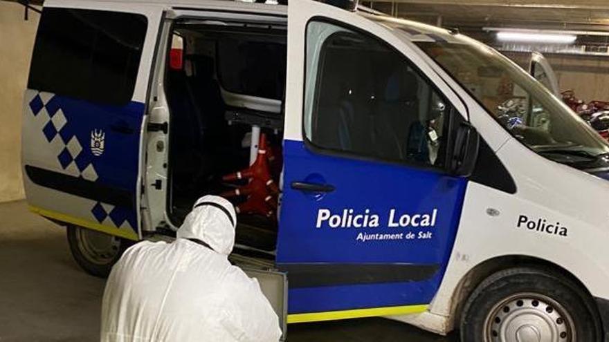 Una persona desinfectant un dels vehicles de la Policia Local de Salt