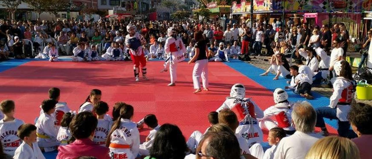 Exhibición de Taekwondo en las fiestas del Carmen. Que la imagen que se ofrece no es la Moaña marinera que toca vender en las Fiestas del Carmen, pero ya ven como esta exhibición organizada por el club Hebe acaparó la atencion de numeroso público. Para que conste, que hay ADN de artes marciales en Moaña, al que no es ajeno la alcaldesa Leticia Santos.  Santos Alvarez