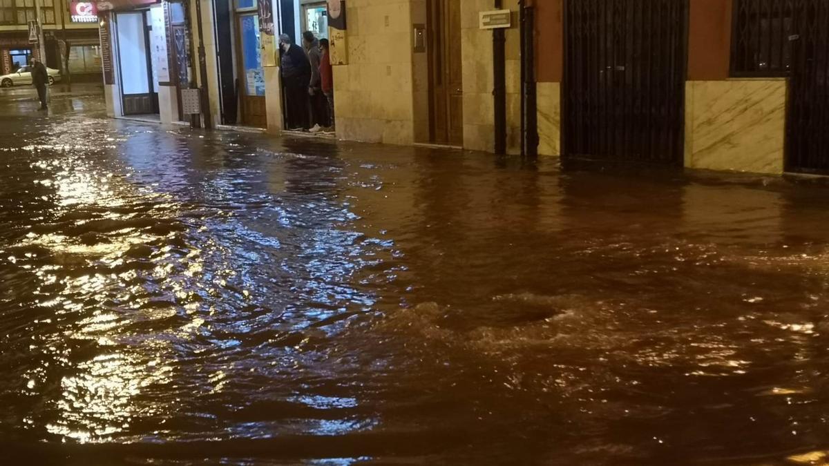 Comerciantes observan el agua acumulada en pocos minutos en la calle Corredera