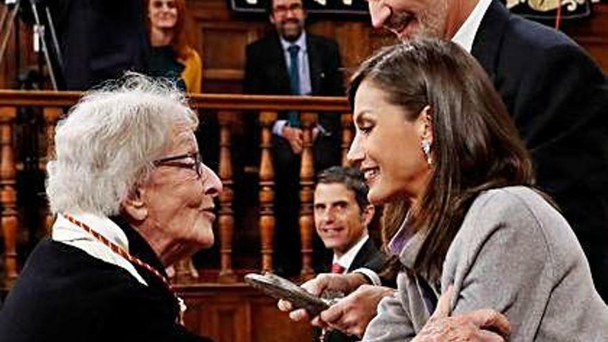 La Reina saluda afectuosamente a la poeta uruguaya en el acto de ayer.