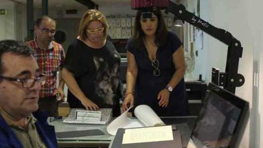 Los concejales Fernando Marcos, Marian Martínez y Sandra Veleda observa como el archivero municipal digitializa un archivo.