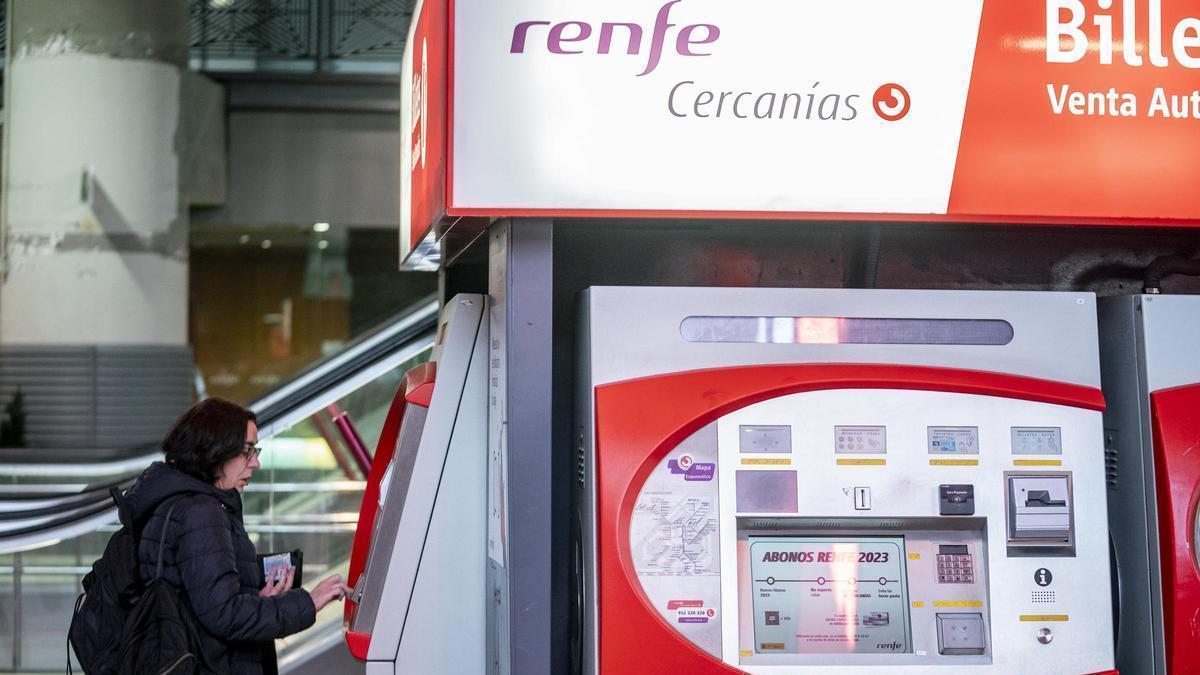 Archivo - Una mujer sin mascarilla obtiene un billete para Cercanías de una de las máquinas de la estación Puerta de Atocha-Almudena Grandes, a 26 de enero de 2023, en Madrid (España).