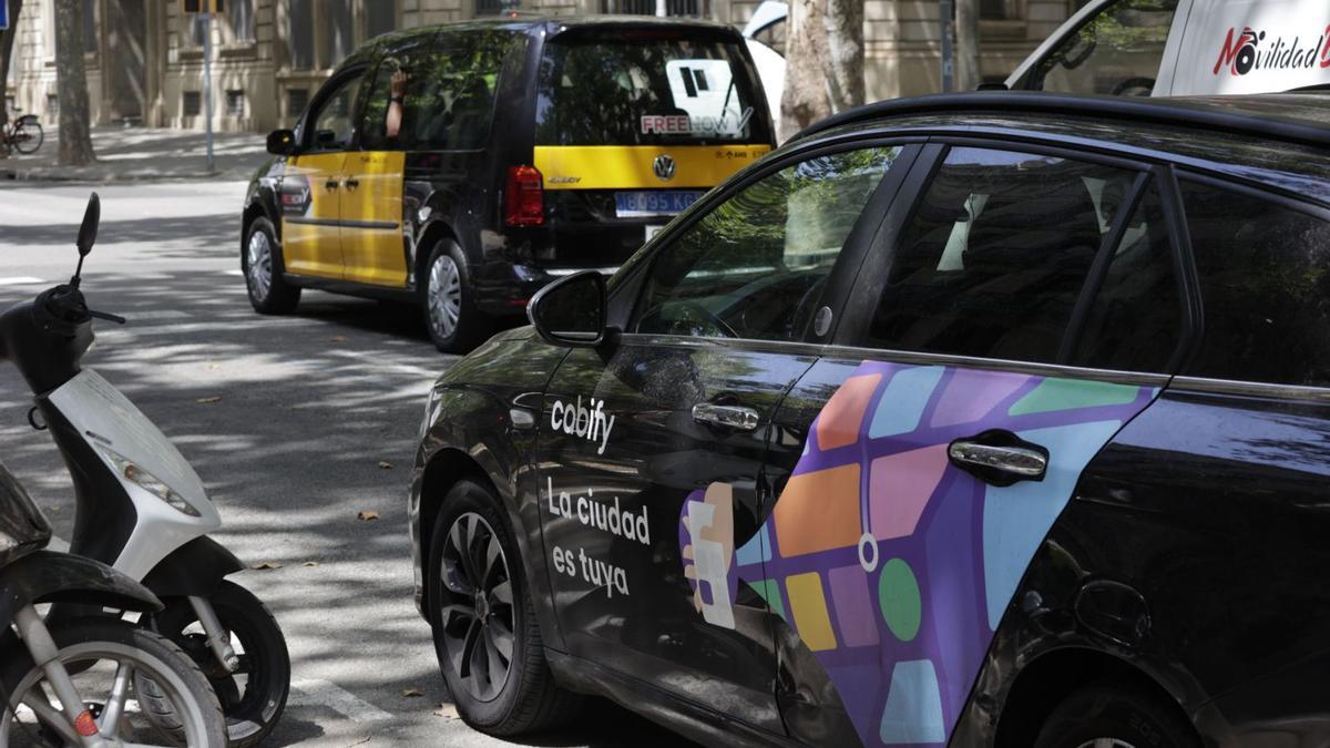 Un cotxe de Cabify i un taxi, a la ronda de Sant Pere de Barcelona
