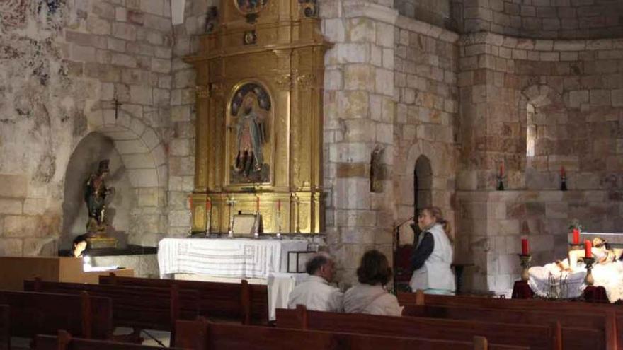 Cabecera de la iglesia, donde se observa a la encargada de la apertura y varios visitantes junto al Yacente.