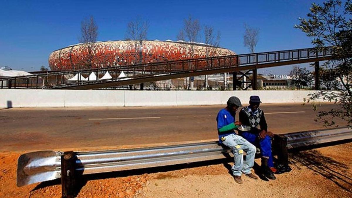 Dos obrers es prenen un descans en les tasques de remodelació de l’estadi de Johannesburg, a Sud-àfrica a menys de tres setmanes de l’inici del mundial de futbol.