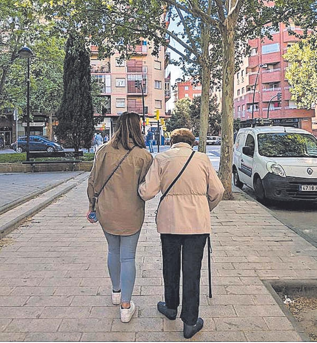 Una voluntaria de Rey Ardid pasea con una persona mayor.