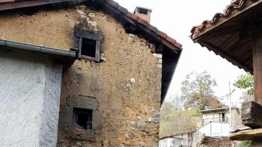 Un bombero, junto a la casa afectada por el fuego.