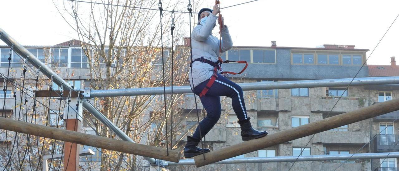 Una participante cruza uno de los puentes del parque de aventura abierto desde ayer en el Xardín do Posío. |   // FERNANDO CASANOVA