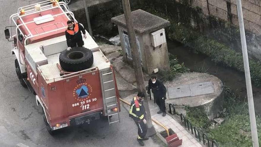 Efectivos de Protección Civil cargan agua junto al cauce del regato Saíñas, en Rodeira. // G.Núñez