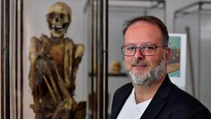 El arqueólogo Serge Lemaître posa ante la momia inca que supuestamente inspiró a Hergé para el personaje Rascar Capac, este martes en el Museo de Arte e Historia de Bruselas.