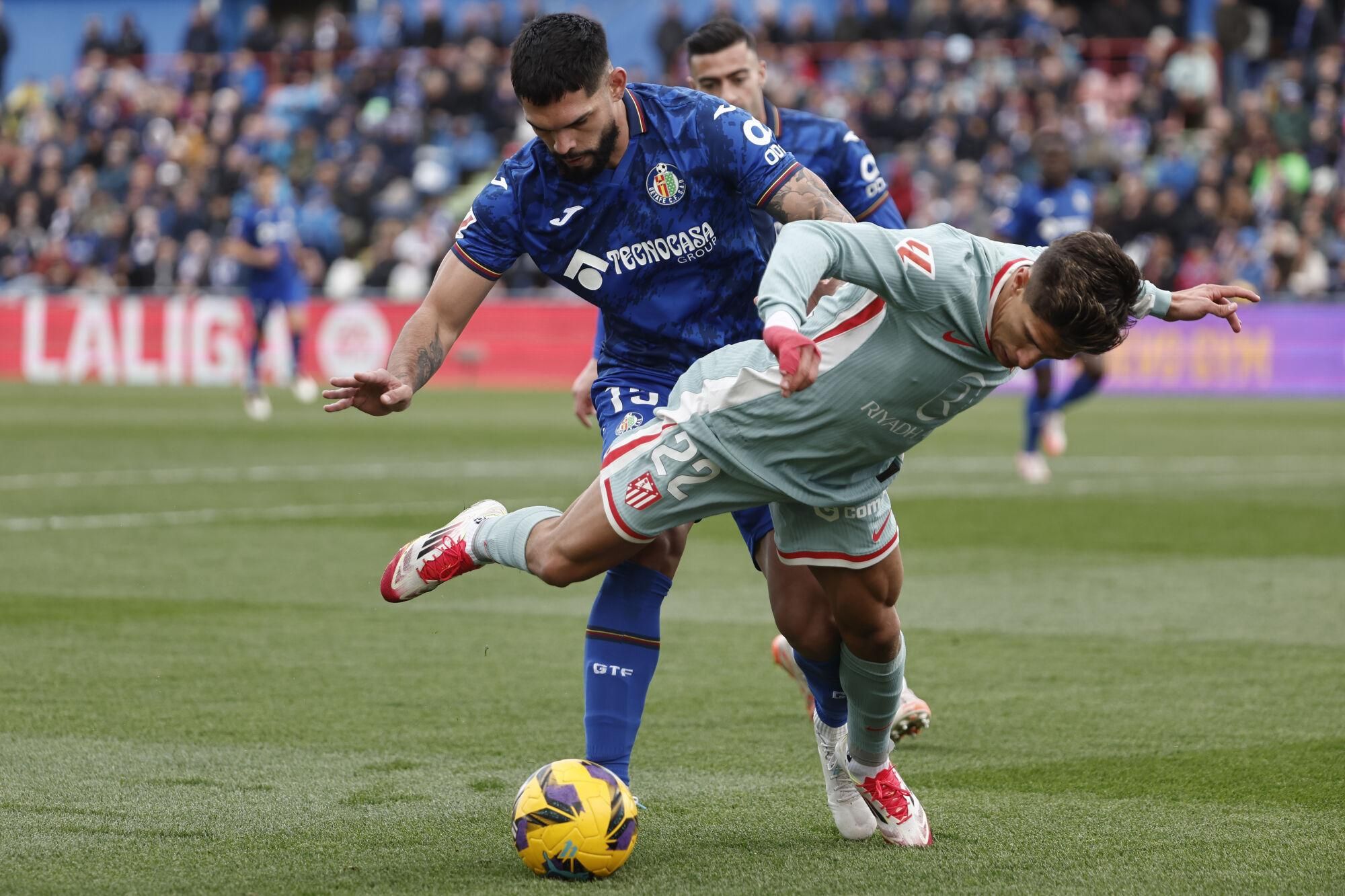 GETAFE (MADRID), 09/03/2025.- El centrocampista del Atlético de Madrid, Giuliano Simeone (d) y el defensa del Getafe Omar Alderete durante el partido de la jornada 27 de Liga que disputan este domingo en el estadio Colisum de Getafe. EFE/Sergio Peréz