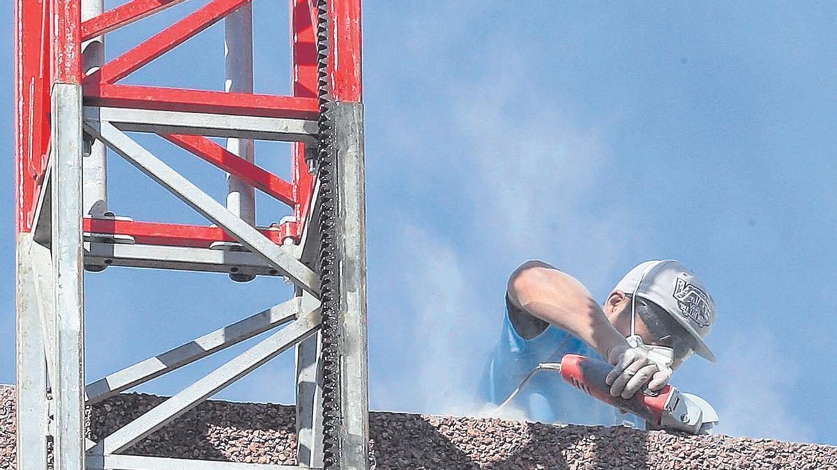 Un obrero trabaja en la fachada de un edificio.