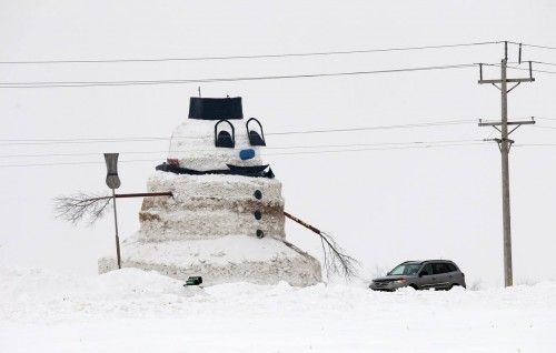 Car passes 50 foot snowman in farm field of Minnesota