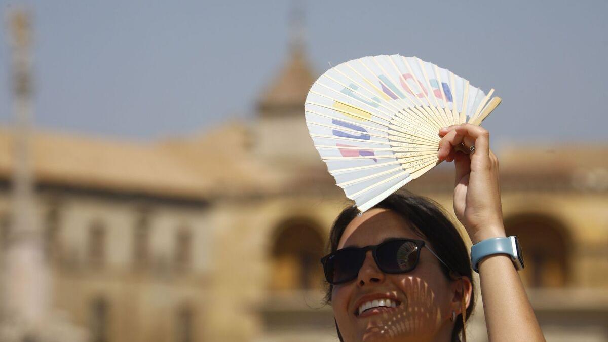 Mujer tapándose la cara con un abanico para que no le de el sol