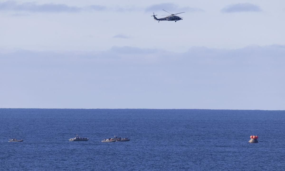 Un helicóptero de la armada de los Estados Unidos sobrevuela la cápsula Orion. Un helicóptero de la armada de los Estados Unidos sobrevuela la cápsula Orion.