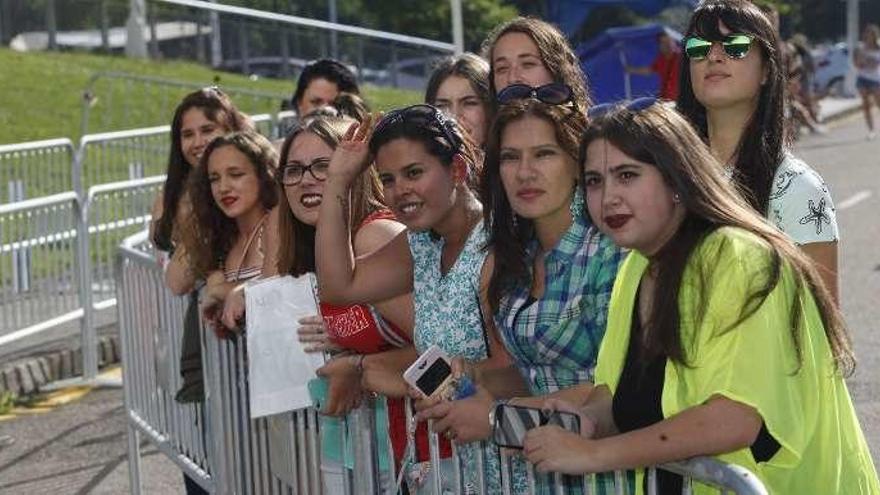 Adriana Oria, a la derecha, junto a otras fans viendo por una puerta abierta los ensayos del cantante.