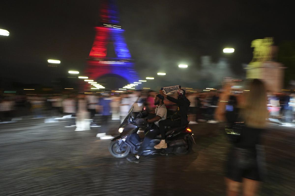 People celebrate PSG's victory by the Eiffel Tower after the Champions League final soccer match between Paris Saint-Germain and Inter Milan, Saturday, May 31, 2025 in Paris. (AP Photo/Aurelien Morissard)