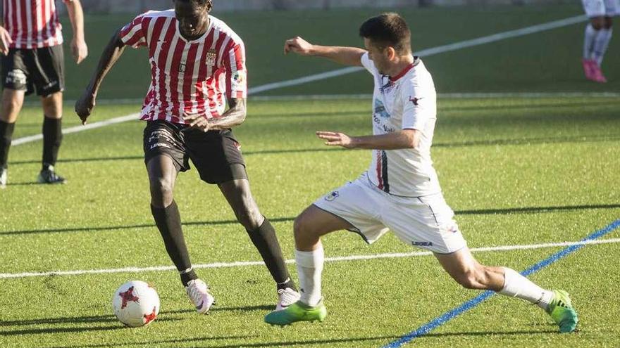 Saha, con el balón, presionado por el jugador del Siero Andrés Cabranes.