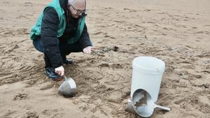 Un voluntario recoge pellets en la playa de La Arena, en Muskiz, Vizcaya.