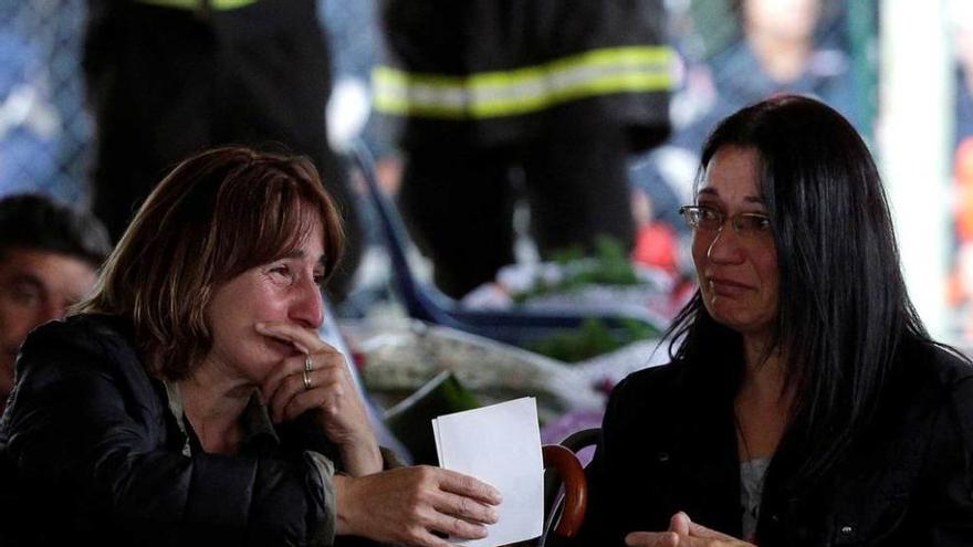 Dos mujeres, ante dos ataúdes.