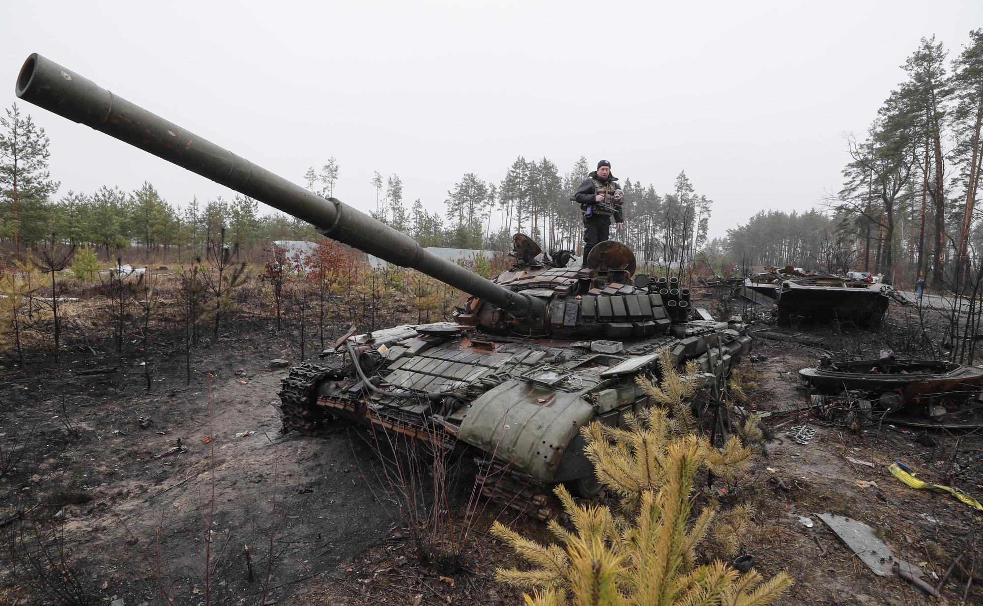 Un policía ucraniano inspecciona un tanque ruso después de que las tropas ucranianas hayan retomado el control de Dmitrivka, en los alrededores de Kiev.