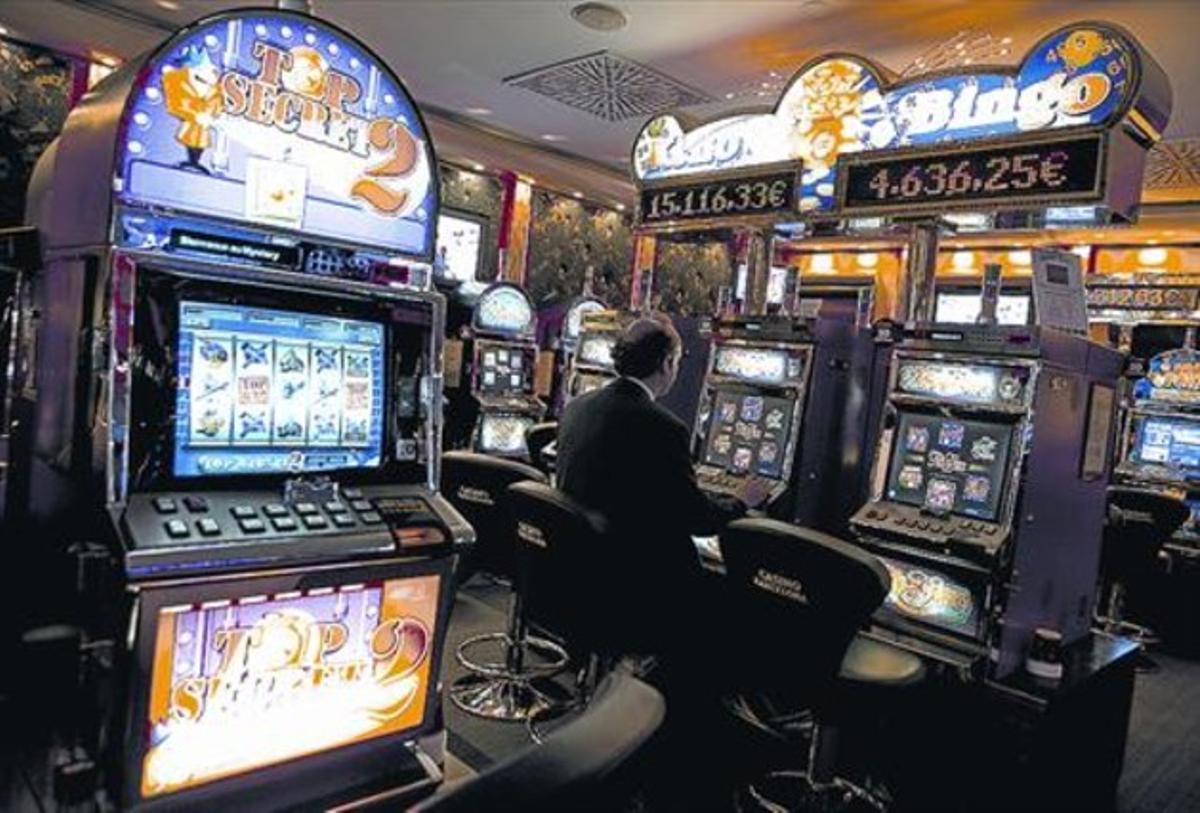Un home juga a les màquines escurabutxaques del Casino de Barcelona.