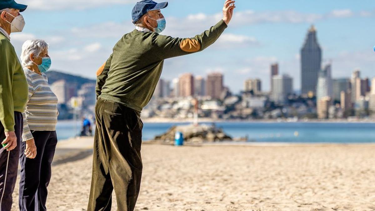 Varios turistas de la tercera edad juegan a la petanca en la playa de Benidorm, el pasado invierno.