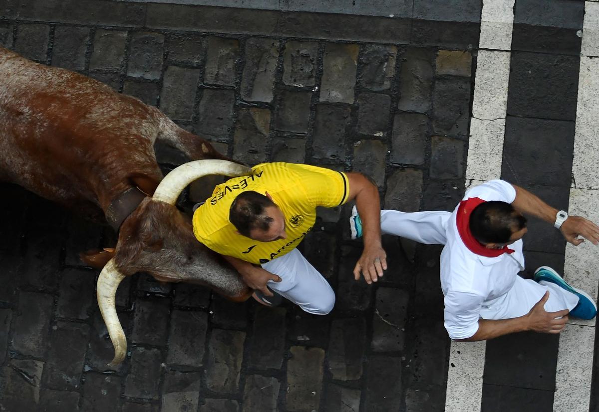 Los participantes corren delante de un toro durante el encierro de las fiestas de San Fermín en Pamplona.