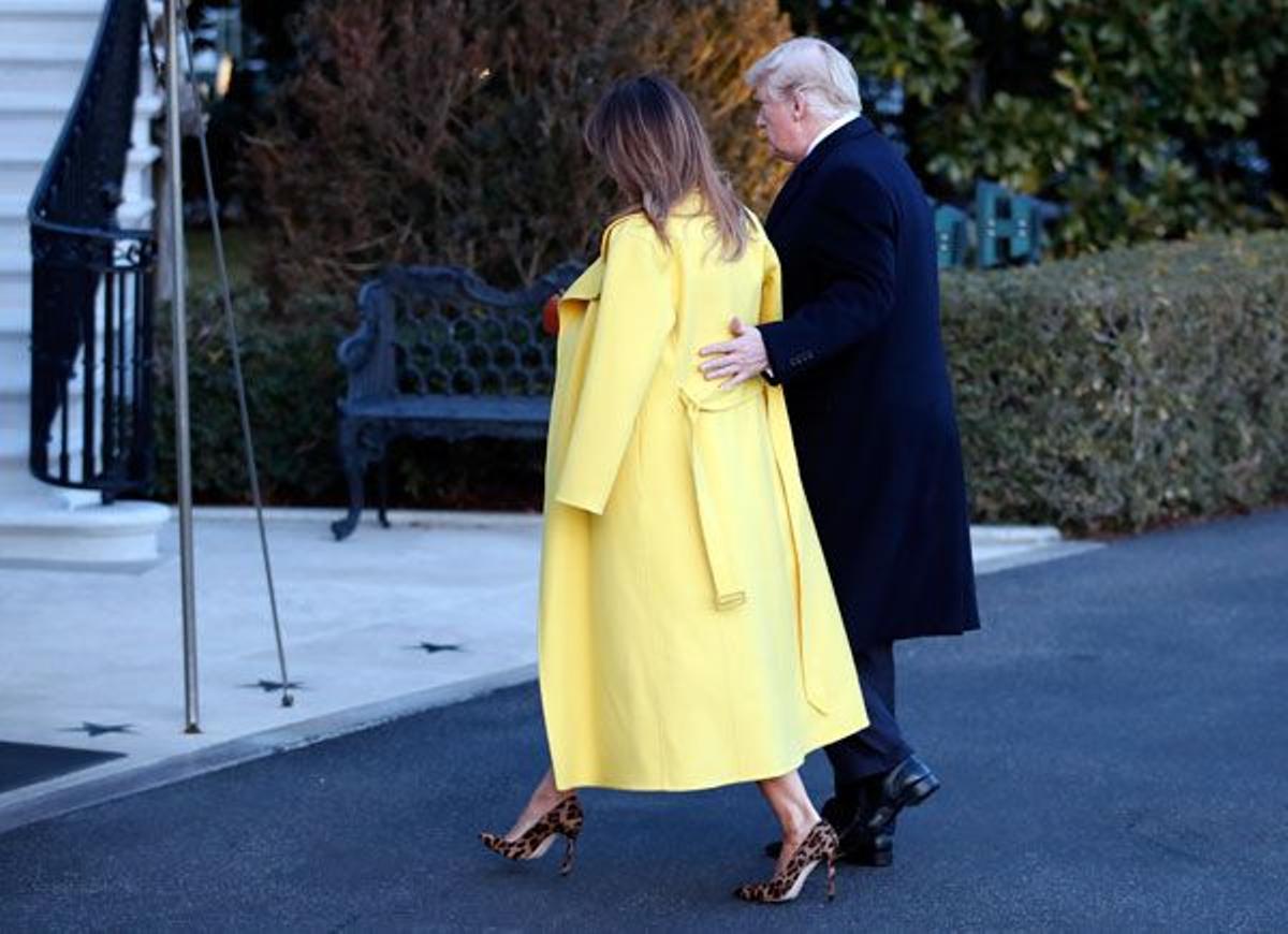 Melania Trump con jersey, abrigo amarillo, falda de piel en marrón y stilettos