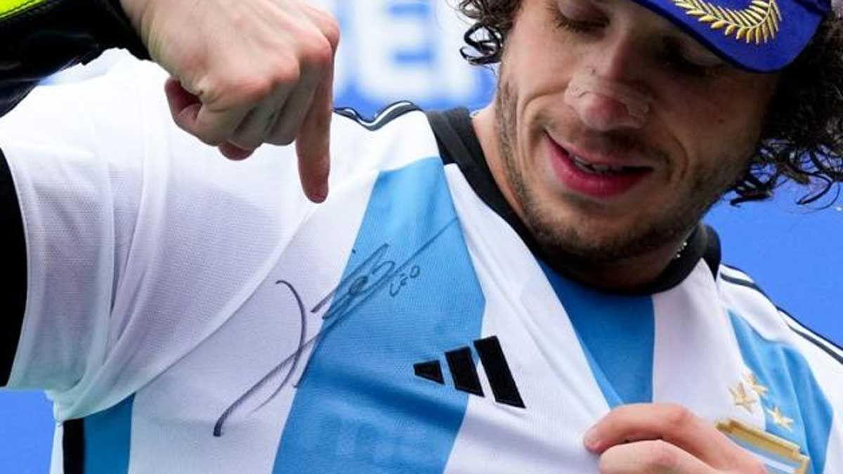 Marco Bezzecchi muestra la firma de Leo Messi en la camiseta albiceleste que subió al podio en Argentina