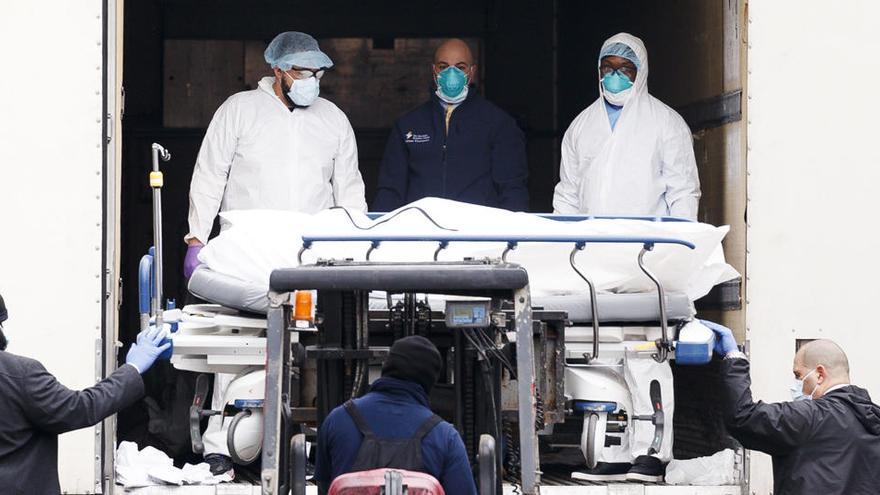 Los profesionales médicos de los hospitales trasladan un cuerpo en una camilla.