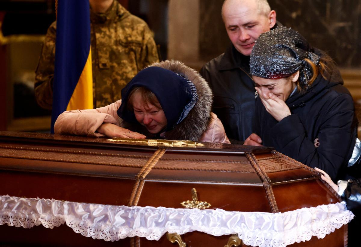 Olena, madre de Denys Snihur, de 25 años, un guardia fronterizo convertido en soldado, asesinado por bombardeos rusos en la ciudad norteña de Ovruch, y su nuera Carina lloran junto a su ataúd durante el servicio conmemorativo en Saints Peter and Paul Garrison. Iglesia, en Lviv, Ucrania