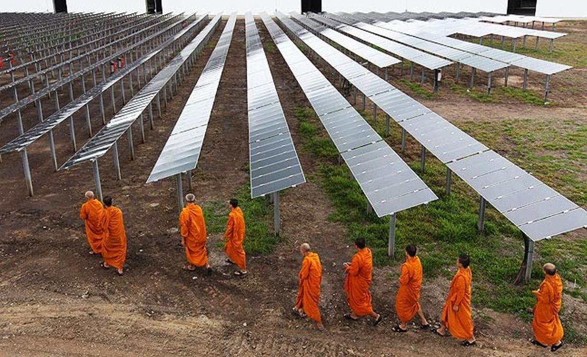 Unos monjes budistas caminan este martes por el nuevo parque solar Sai Sena, en la ciudad de Ayutthaya (Tailanda). Fue diseñado e instalado por la empresa alemana Conergy y será gestionado por las tailandesas Ratchaburi Electricity y Yanhee Solar Power. Estas dos empresas también desarrollan otros siete proyectos de energía solar en Tailandia.